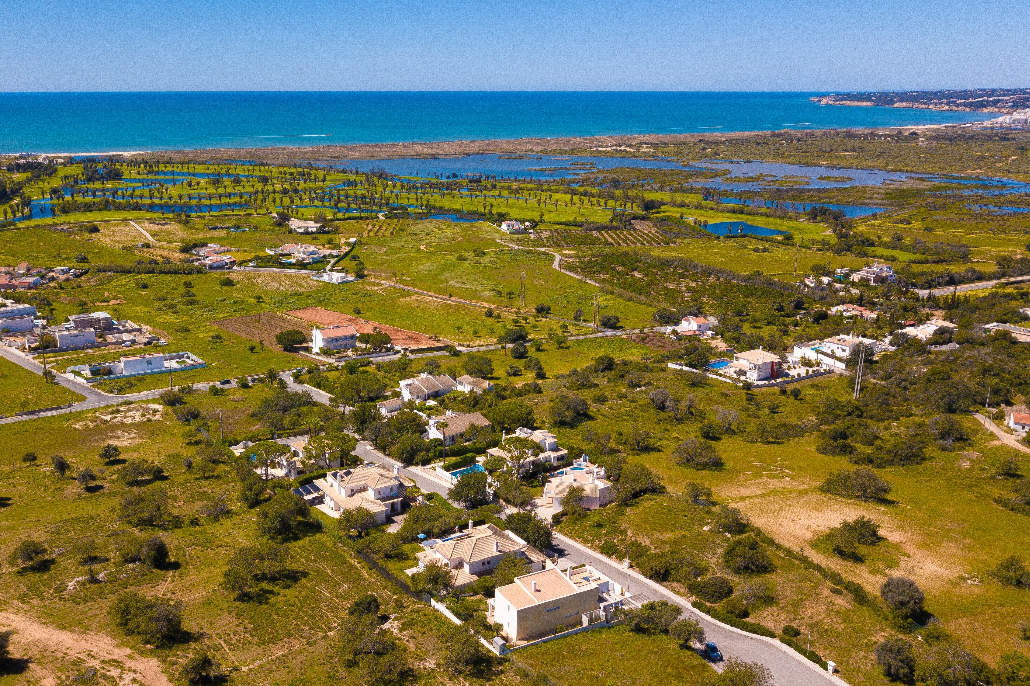 Vista aérea das moradias, campos e costa algarvia